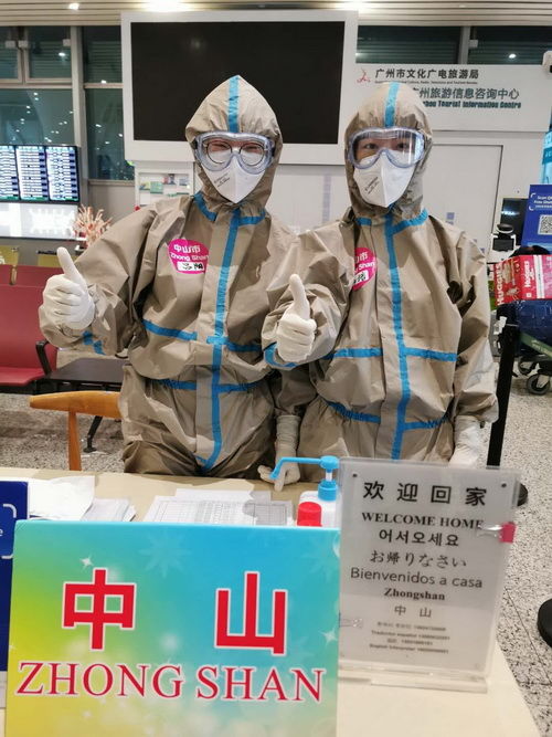 冯培（右）与同伴坚守岗位，欢迎从各地飞回的旅客回中山_调整大小.jpg